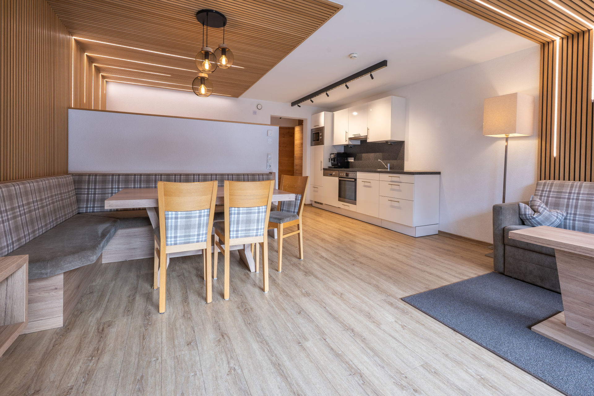 Großzügiger Wohnraum mit vollständig ausgestatter Küche und Abgang ins Erdgeschoss zu den Schlaf- und Badzimmern.