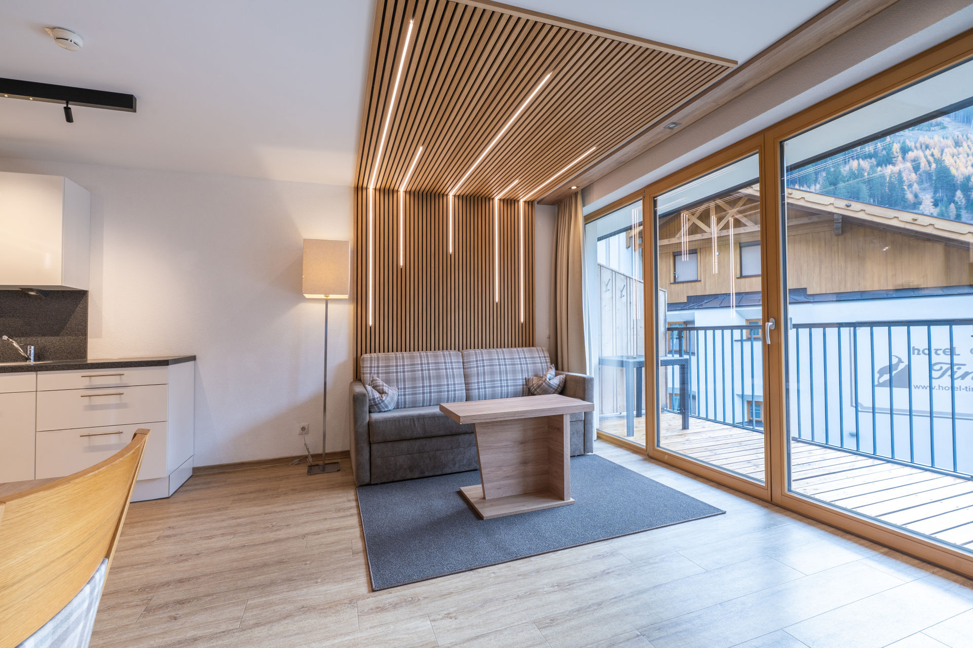 Großzügiger Wohnraum mit vollständig ausgestatter Küche und Abgang ins Erdgeschoss zu den Schlaf- und Badzimmern.